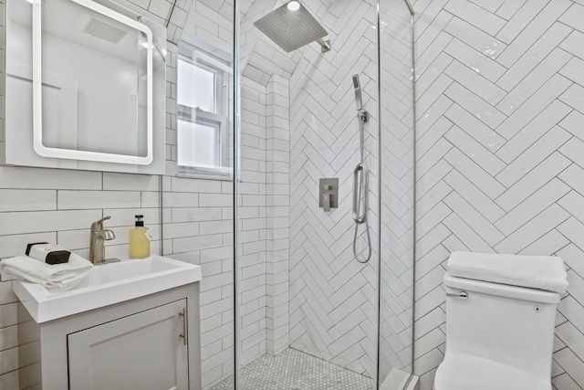 full bathroom with decorative backsplash, toilet, vanity, a shower stall, and tile walls