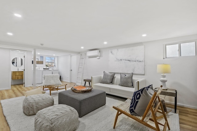 living area featuring light wood finished floors, recessed lighting, baseboards, and a wall mounted AC