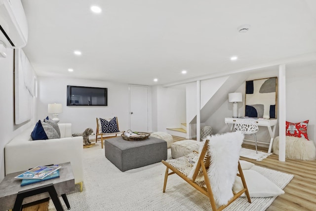 living area with stairway, a wall mounted AC, wood finished floors, and recessed lighting