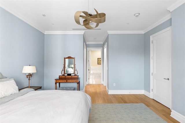 bedroom with ornamental molding and light hardwood / wood-style floors