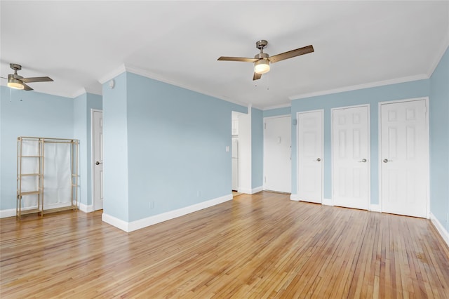 interior space with light wood-style floors, ornamental molding, baseboards, and two closets