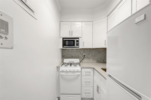 kitchen with white appliances, tasteful backsplash, white cabinets, ornamental molding, and light countertops