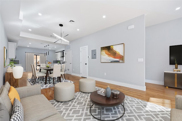 living room with an inviting chandelier and light wood-type flooring