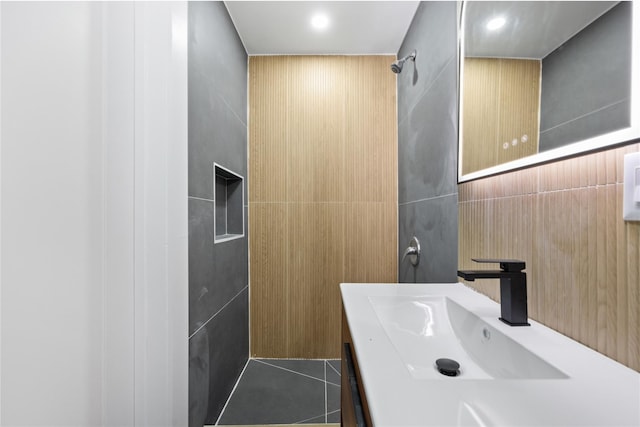 bathroom featuring vanity, tile patterned flooring, and tile walls