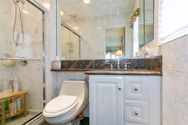 full bathroom featuring a stall shower, tile walls, and vanity