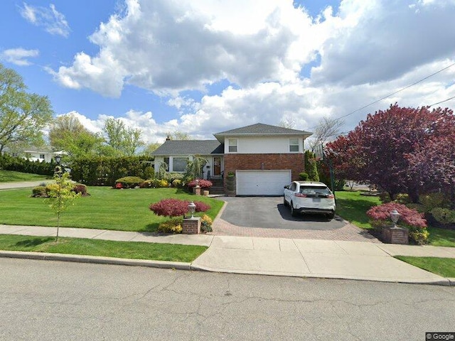 view of front of house with aphalt driveway, a front yard, and an attached garage