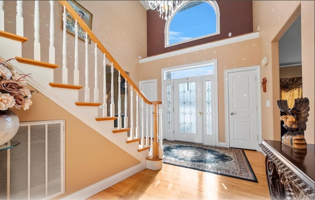 foyer featuring a towering ceiling and hardwood / wood-style floors