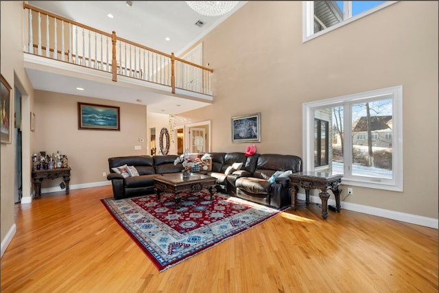 living room featuring a towering ceiling and light wood-type flooring