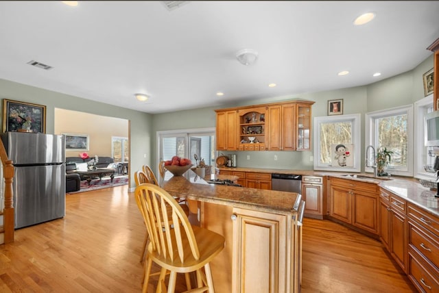 kitchen featuring sink, plenty of natural light, stainless steel appliances, and a kitchen bar