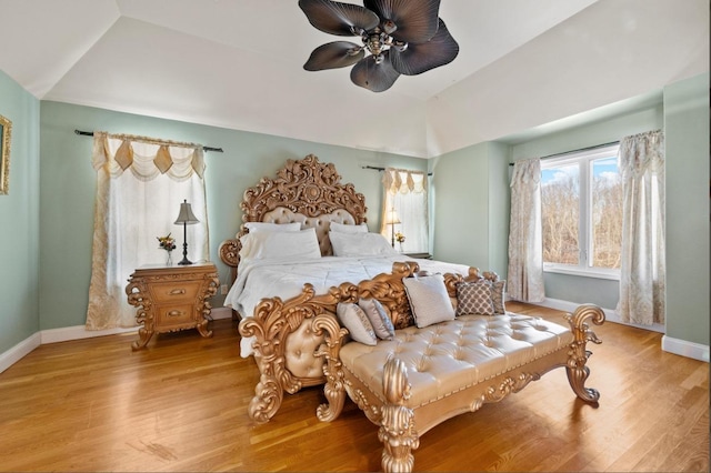 bedroom with ceiling fan, vaulted ceiling, and light wood-type flooring