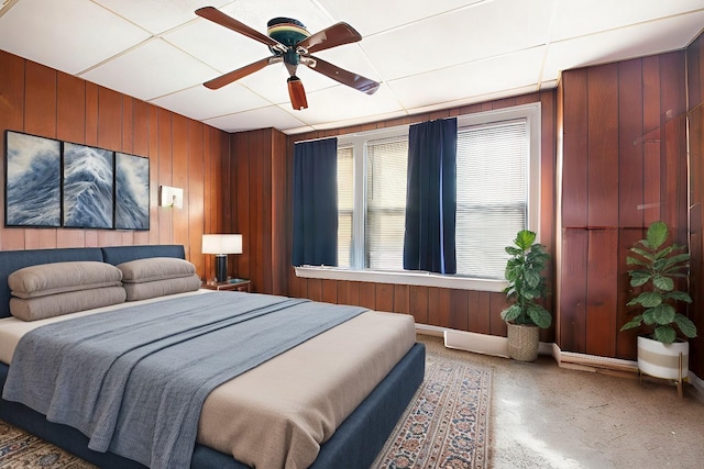 bedroom featuring ceiling fan and wood walls