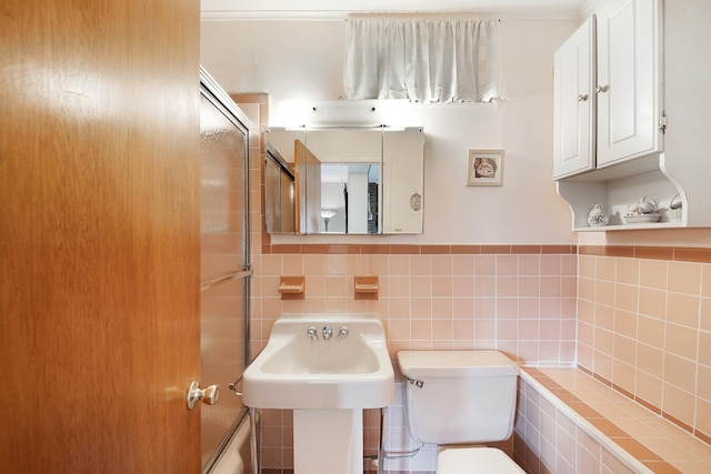 bathroom with tile walls and toilet