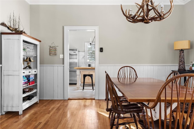 dining room with hardwood / wood-style floors, crown molding, and a chandelier