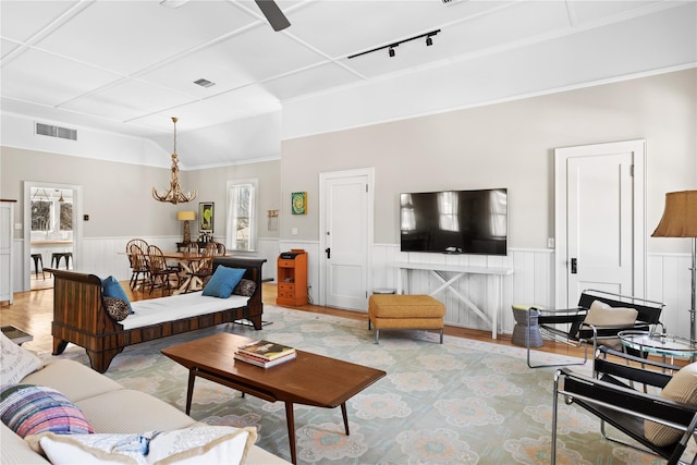 living room featuring track lighting, a chandelier, and light wood-type flooring