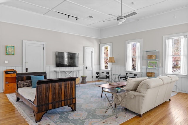 living room with track lighting, ceiling fan, and light hardwood / wood-style flooring