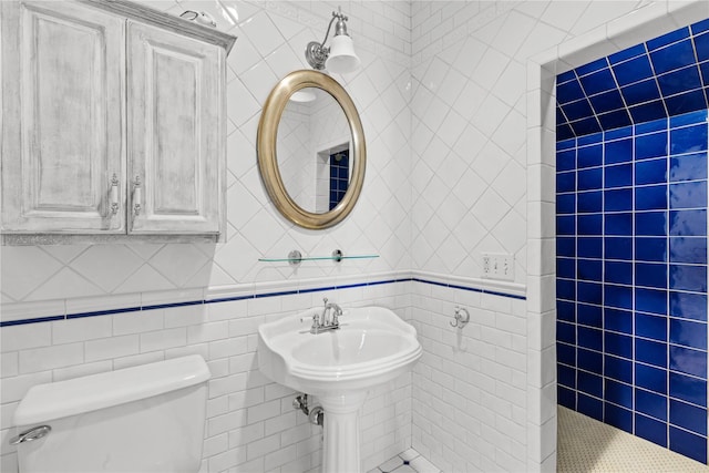 bathroom with toilet and tile walls