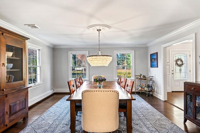 dining room featuring a chandelier, visible vents, baseboards, ornamental molding, and dark wood-style floors