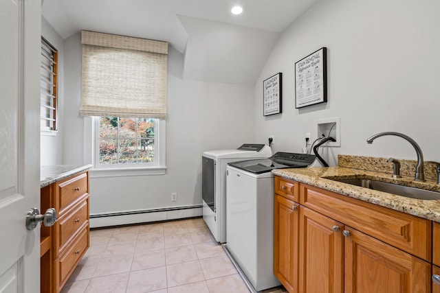 laundry area featuring cabinet space, light tile patterned floors, independent washer and dryer, baseboard heating, and a sink