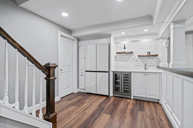 kitchen featuring wine cooler, open shelves, light countertops, white cabinets, and a sink