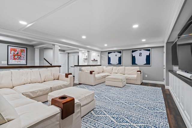 living room with decorative columns, a raised ceiling, dark wood-style flooring, crown molding, and recessed lighting