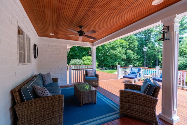 wooden deck featuring a pool, ceiling fan, and an outdoor living space