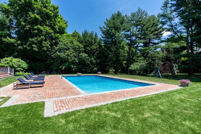 outdoor pool with a patio area, a playground, and a lawn