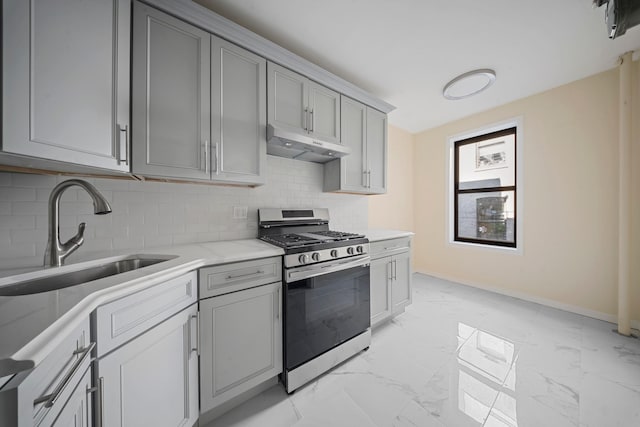 kitchen featuring under cabinet range hood, a sink, marble finish floor, stainless steel gas range, and gray cabinets