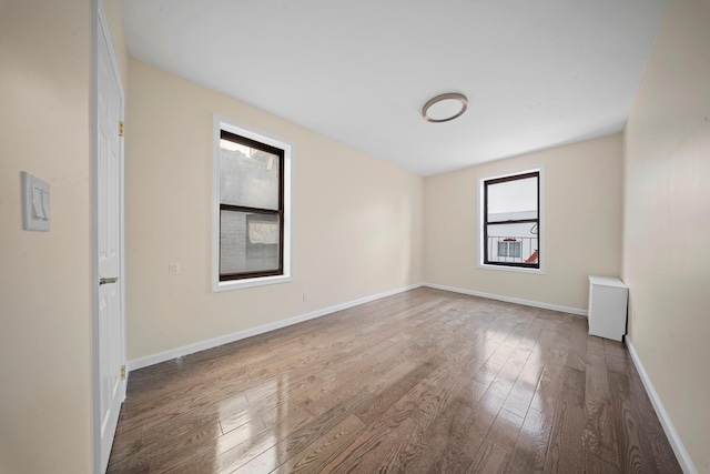 empty room with baseboards and wood finished floors