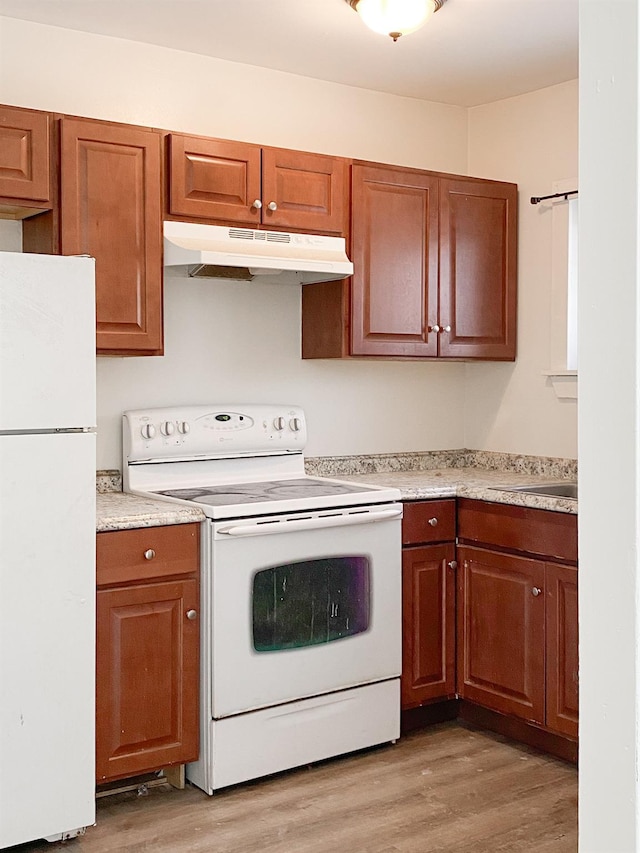 kitchen with white appliances, sink, and light wood-type flooring