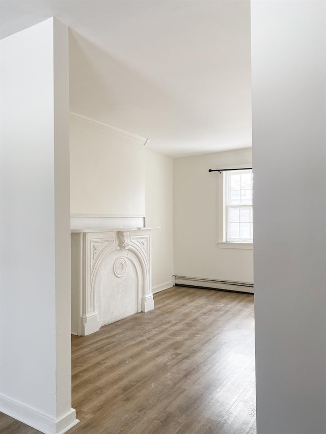 unfurnished living room featuring hardwood / wood-style flooring and baseboard heating