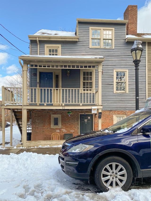 view of front of property featuring a porch and a balcony