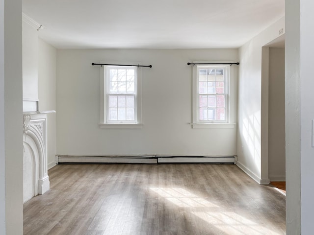 unfurnished living room with baseboard heating and light wood-type flooring