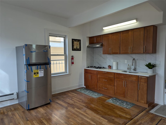 kitchen with sink, gas cooktop, stainless steel refrigerator, dark hardwood / wood-style floors, and tasteful backsplash