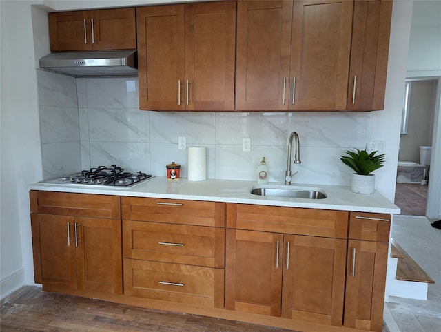 kitchen featuring tasteful backsplash, sink, dark wood-type flooring, and stainless steel gas cooktop