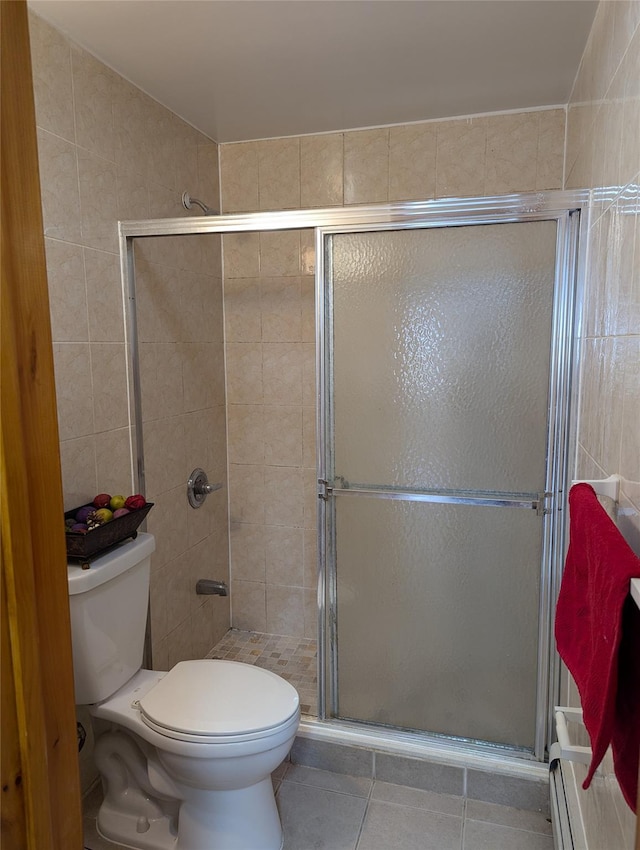 bathroom featuring toilet, tile walls, tile patterned floors, and walk in shower