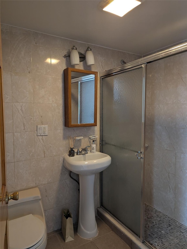 bathroom featuring an enclosed shower, tile patterned floors, toilet, and tile walls