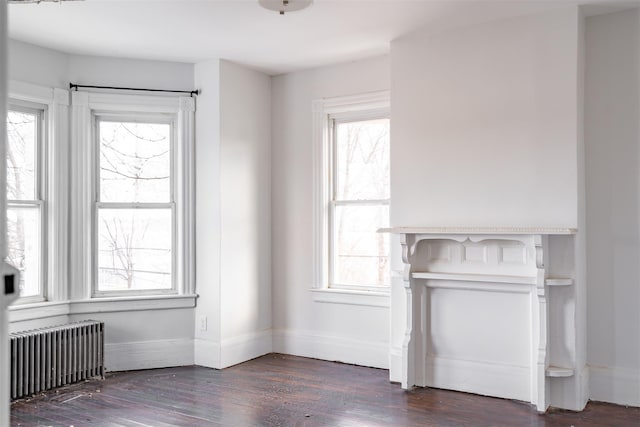 unfurnished living room featuring dark hardwood / wood-style flooring and radiator