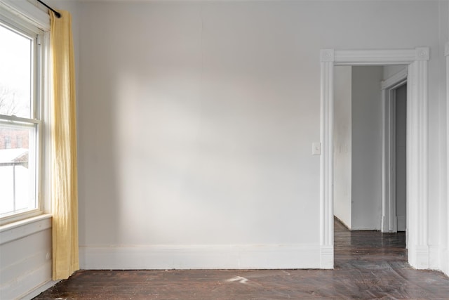 spare room featuring a wealth of natural light and dark hardwood / wood-style flooring