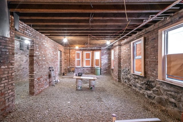 misc room featuring plenty of natural light and brick wall