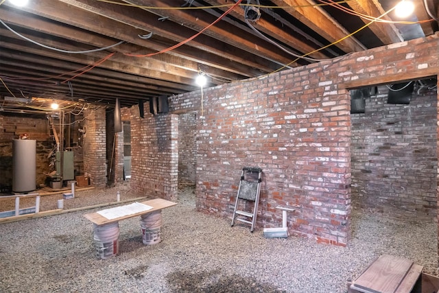 basement with gas water heater and brick wall