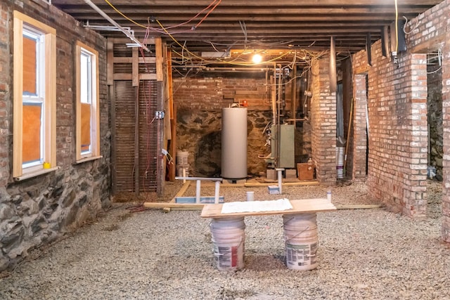 interior space featuring water heater and brick wall