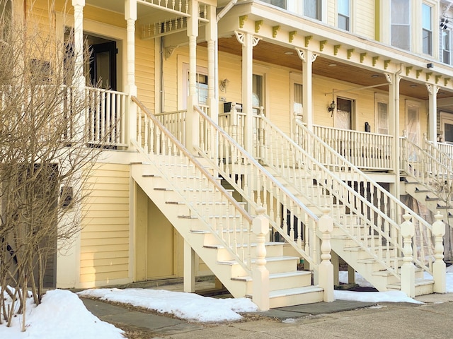 snow covered property entrance with a porch