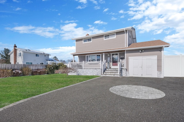 view of front facade with a garage, covered porch, and a front lawn