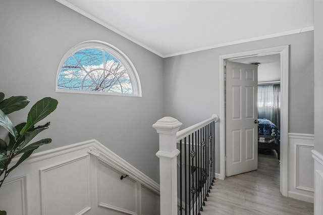 staircase with hardwood / wood-style floors and crown molding