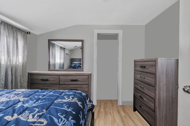 bedroom featuring vaulted ceiling and light hardwood / wood-style flooring