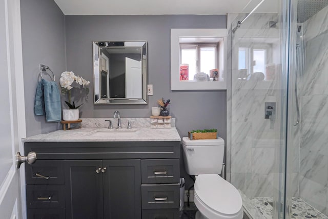 bathroom featuring vanity, an enclosed shower, and toilet