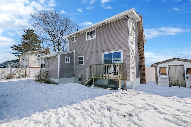 snow covered property featuring a storage unit