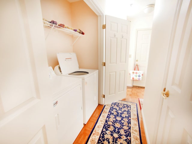 laundry area with independent washer and dryer and light parquet flooring