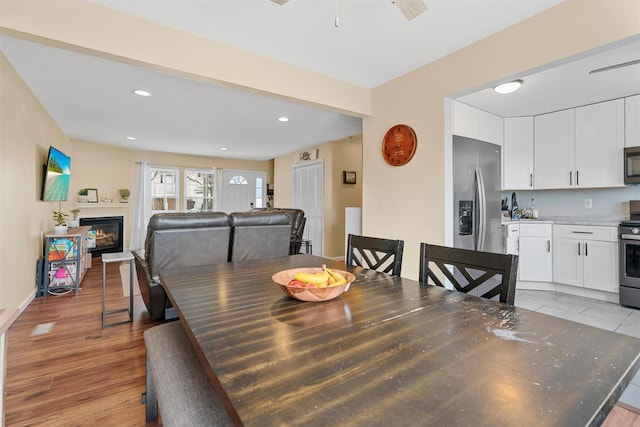 dining space with light hardwood / wood-style floors and ceiling fan