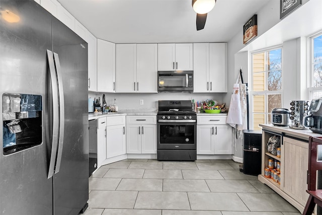 kitchen with white cabinetry, sink, light tile patterned floors, ceiling fan, and stainless steel appliances